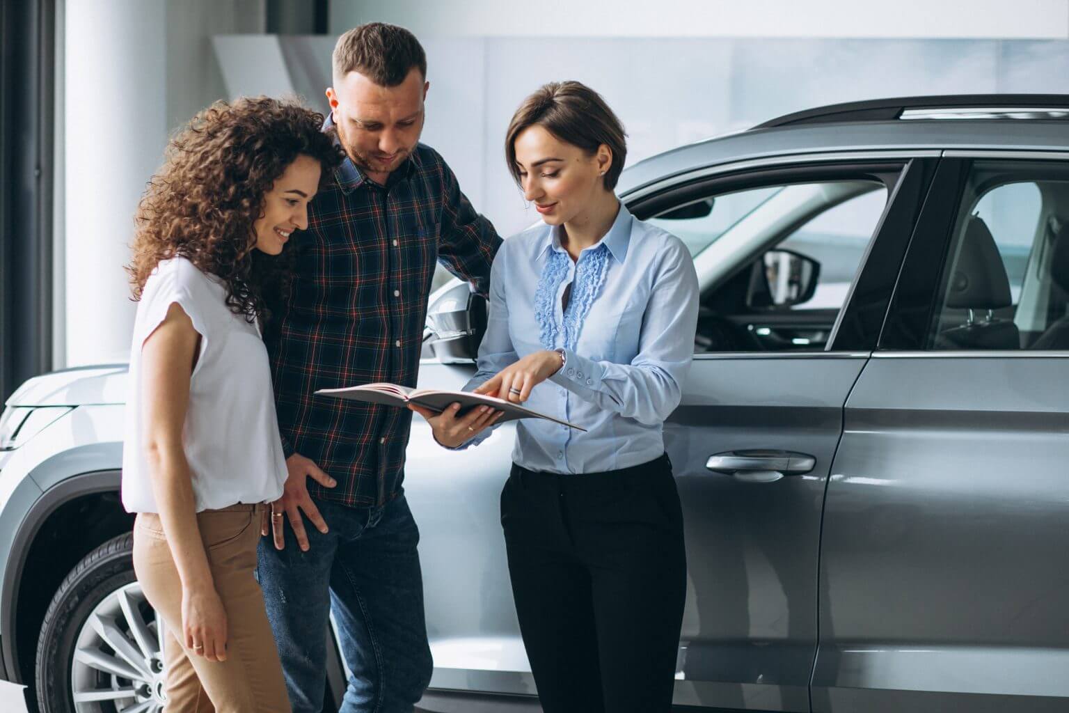 Young couple talking sales person car showroom 1536x1024