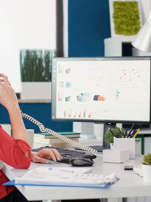Office secretary using landline phone to talk about work, having remote conversation to create business growth. Female employee answering telephone call in startup company office.
